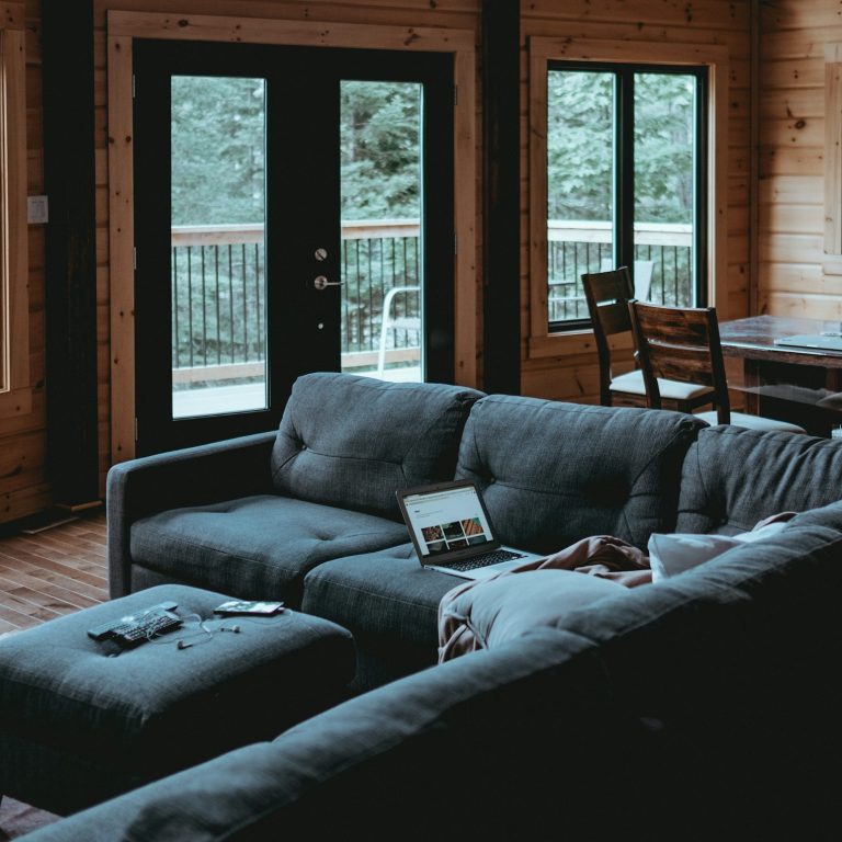 Beratung ist überall möglich Gemütliches Wohnzimmer mit Couch, Kaffeetisch und großen Fenstern zum Außenbereich.