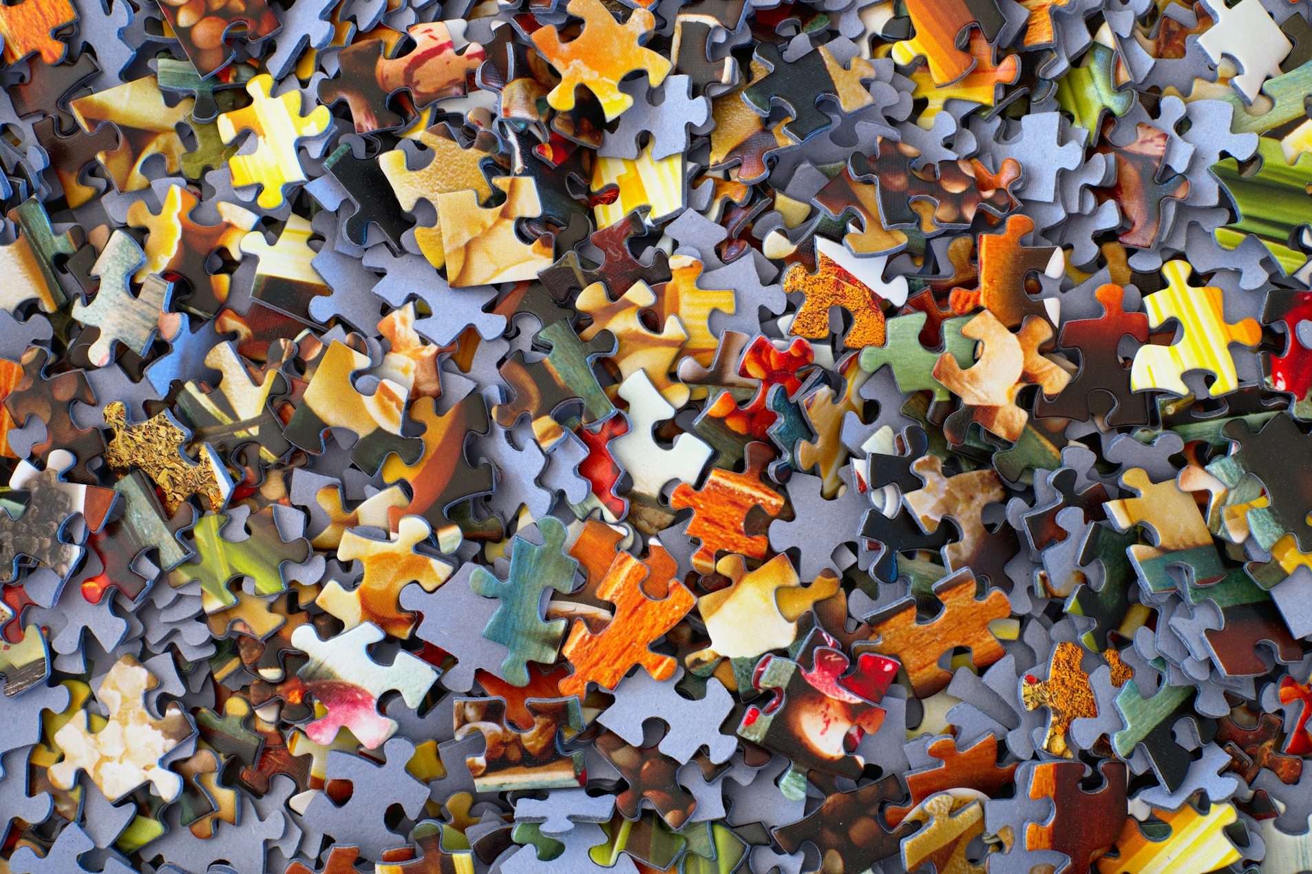 das Lebenspuzzle Bunte, verstreute Puzzlestücke in verschiedenen Farben und Formen.